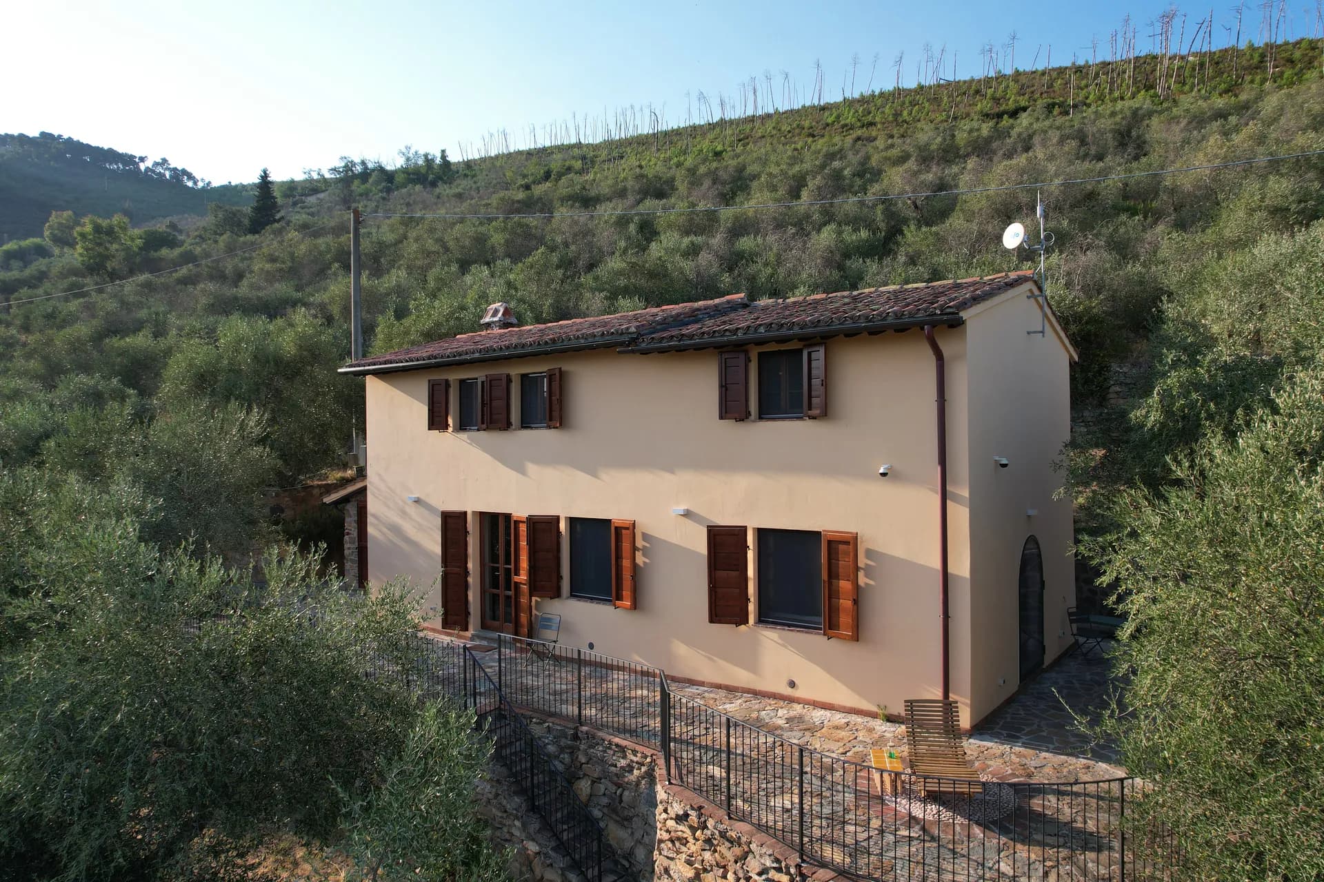 The ochre facade of Casale Eleo among the olive trees