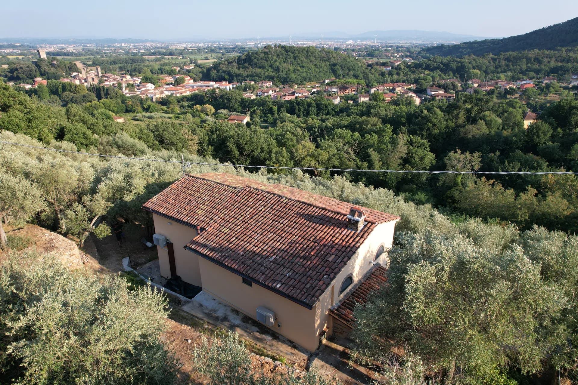 The ochre facade of Casale Eleo among the olive trees