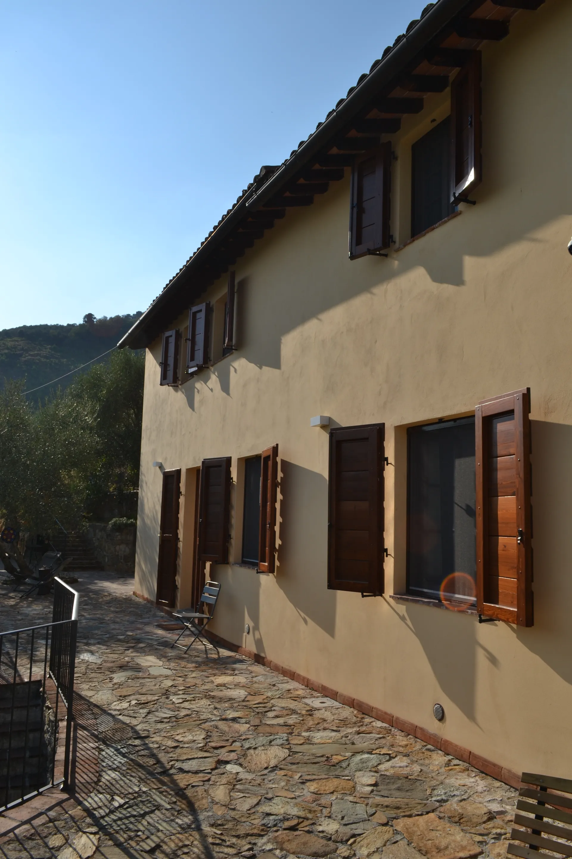 The ochre facade of Casale Eleo among the olive trees
