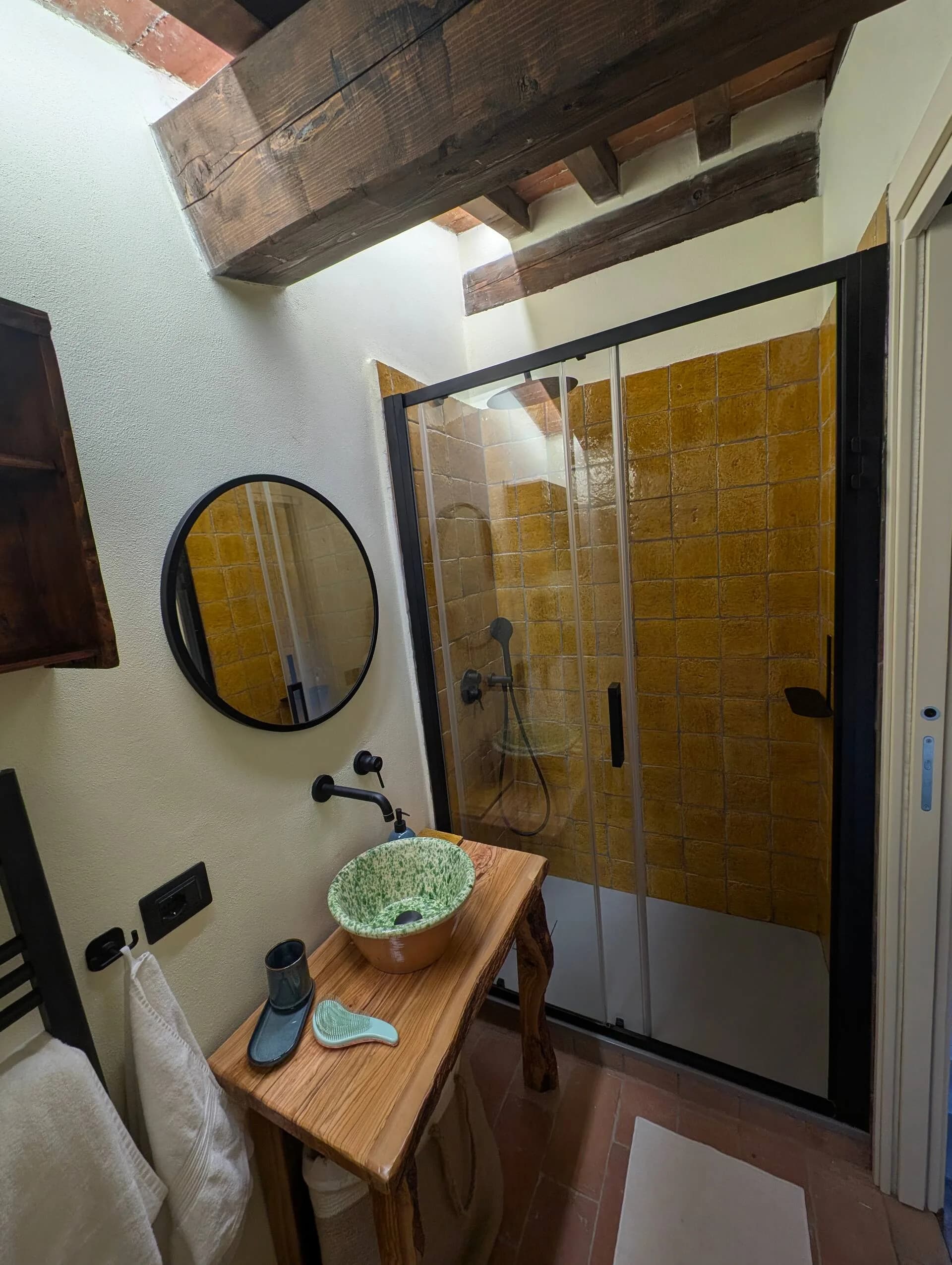 Bathroom with yellow zellige tiles and a round mirror
