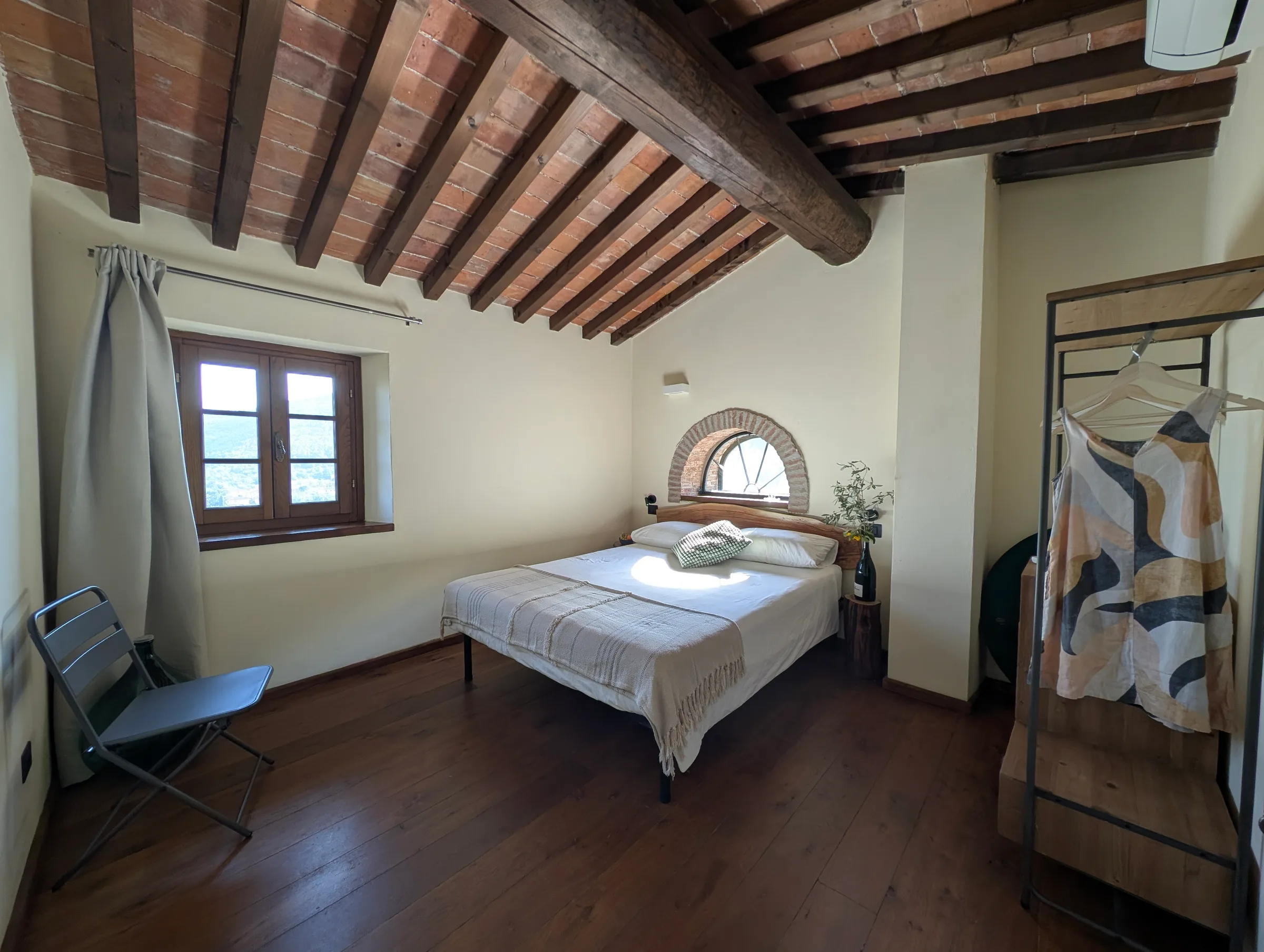 The second bedroom, with a queen bed beneath an arched window