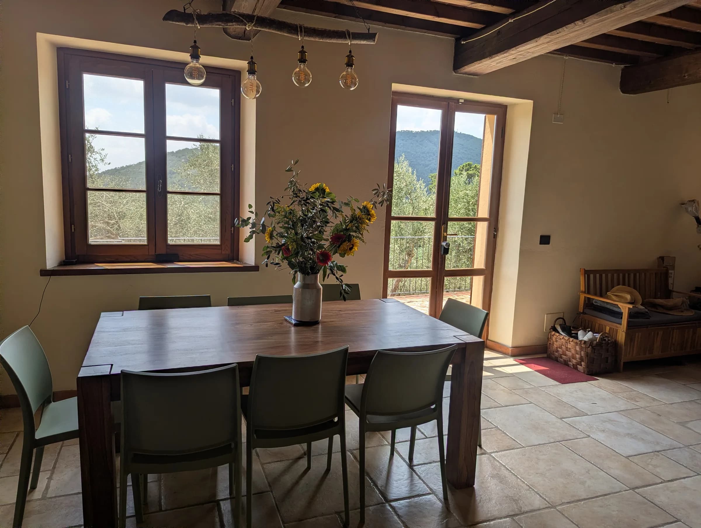 Dining table set for eight beneath wood-beamed ceilings